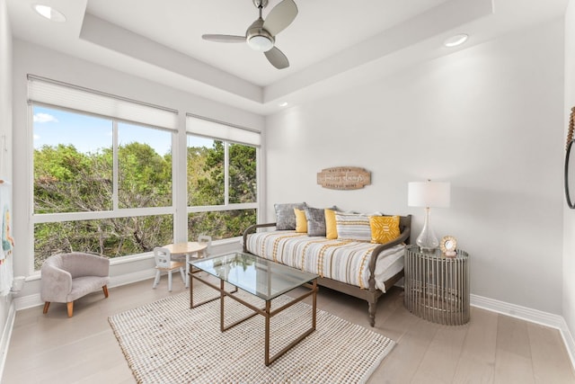 bedroom with baseboards, recessed lighting, a raised ceiling, and multiple windows