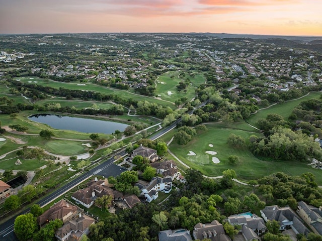 aerial view at dusk with a residential view, a water view, and golf course view