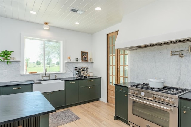 290 County Road 207, Liberty Hill, TX 78642 - kitchen with high end stove, green cabinets, dark countertops, and recessed lighting