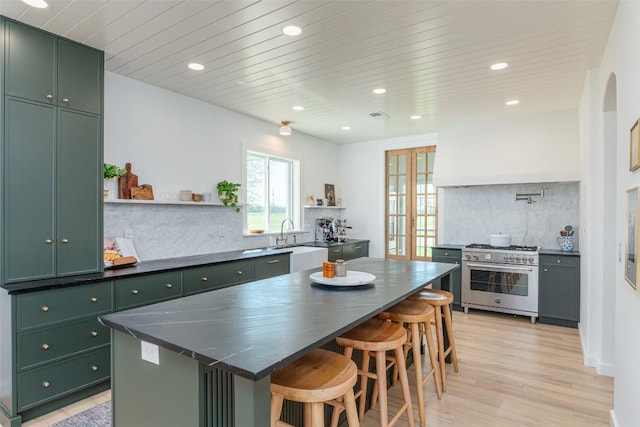 290 County Road 207, Liberty Hill, TX 78642 - kitchen with green cabinetry, high end stove, recessed lighting, open shelves, and dark countertops
