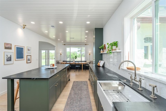 290 County Road 207, Liberty Hill, TX 78642 - kitchen with light wood-style floors, a sink, arched walkways, a kitchen bar, and modern cabinets