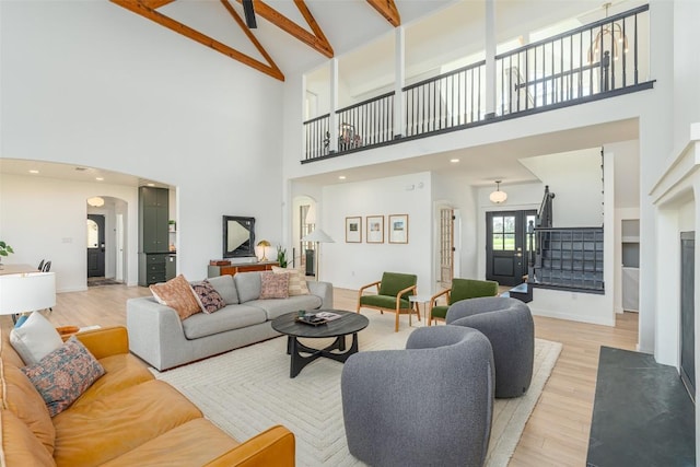 290 County Road 207, Liberty Hill, TX 78642 - living room with high vaulted ceiling, arched walkways, light wood-style floors, beam ceiling, and stairs