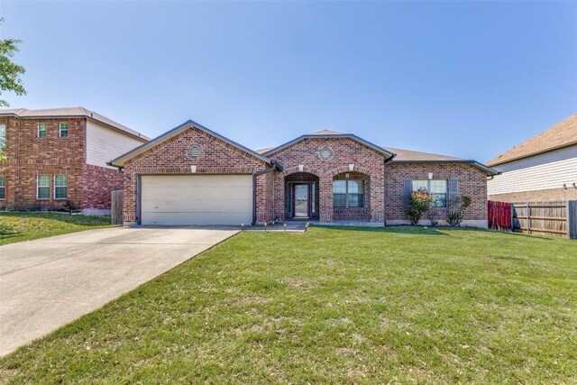 single story home featuring an attached garage, fence, brick siding, a front lawn, and driveway