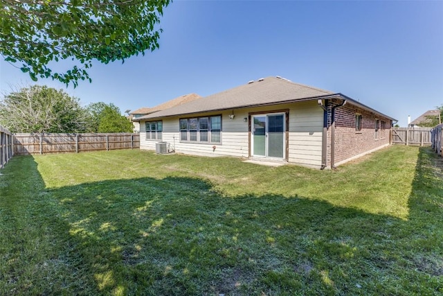 back of property featuring a yard, a fenced backyard, and central AC unit