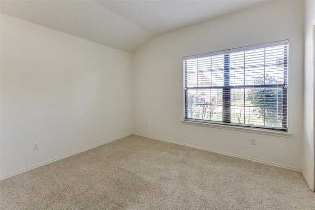 spare room with carpet floors, baseboards, plenty of natural light, and lofted ceiling