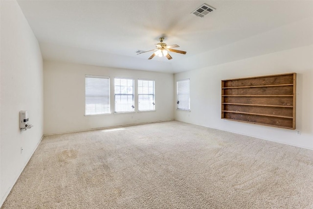 carpeted empty room with visible vents and ceiling fan