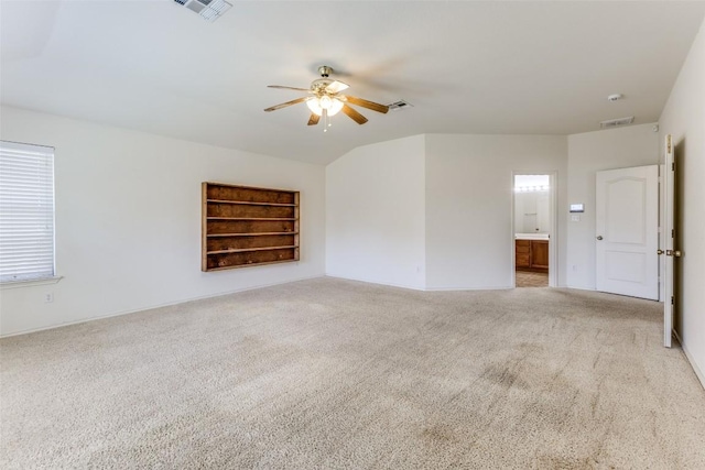 carpeted empty room with baseboards, a ceiling fan, and visible vents