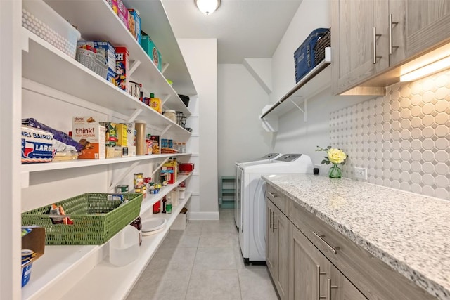 washroom with light tile patterned floors, separate washer and dryer, and laundry area