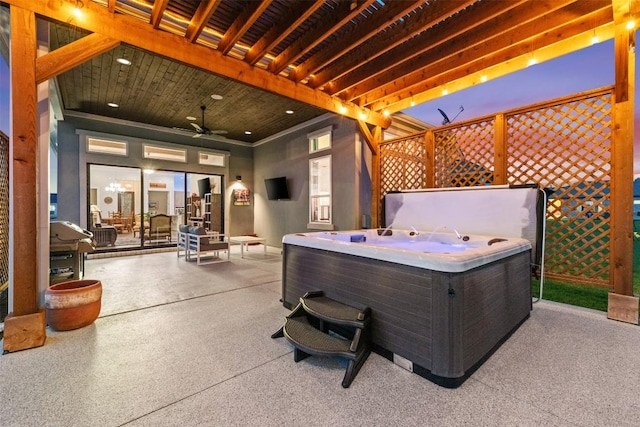 view of patio / terrace featuring fence, a ceiling fan, and a hot tub