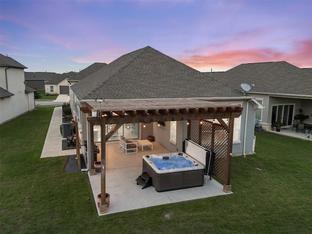 back of property at dusk featuring a shingled roof, a hot tub, a yard, a patio area, and cooling unit