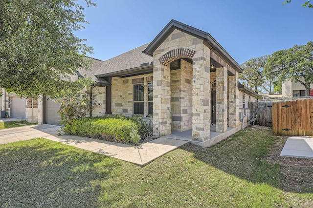 2013 Garretts Way, Manchaca, TX 78652 - view of front of home with stone siding, driveway, an attached garage, and a shingled roof
