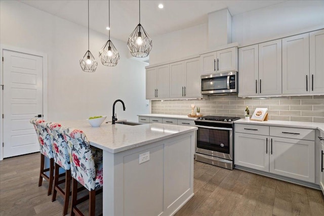 7009 Zachary Dr, Austin, TX 78724 - kitchen featuring stainless steel appliances, decorative backsplash, a kitchen bar, dark wood finished floors, and recessed lighting