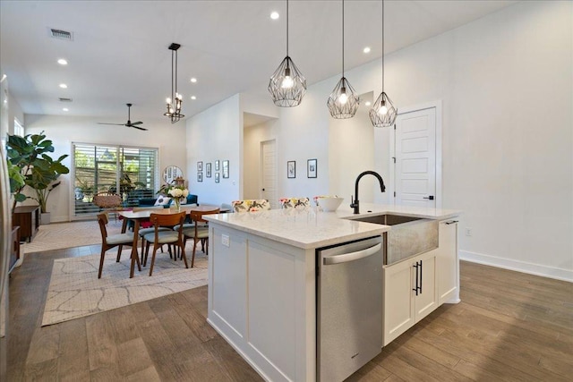 7009 Zachary Dr, Austin, TX 78724 - kitchen with dishwasher, dark wood-style floors, an island with sink, a ceiling fan, and hanging light fixtures