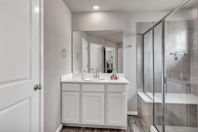 100 Vickers St, Georgetown, TX 78628 - bathroom featuring baseboards, wood finished floors, vanity, and tiled shower