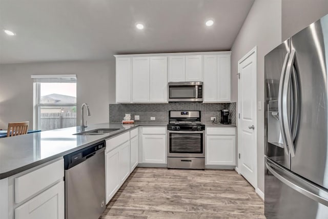 100 Vickers St, Georgetown, TX 78628 - kitchen with a sink, decorative backsplash, stainless steel appliances, and light wood-type flooring