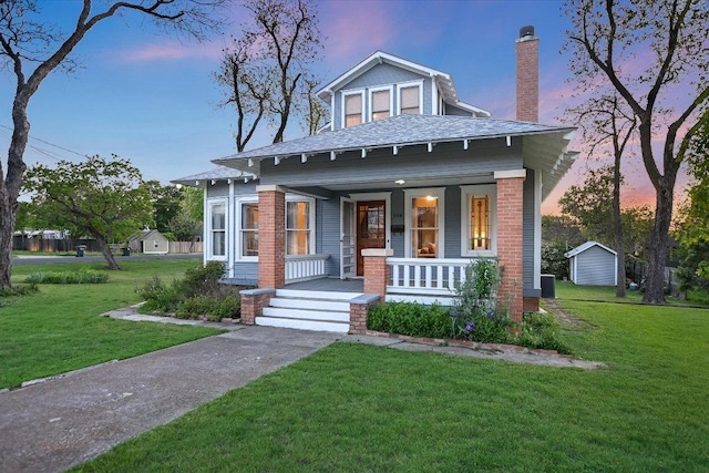 508 S Walnut St, Georgetown, TX 78626 - view of front facade with covered porch, a front yard, a chimney, and a shingled roof
