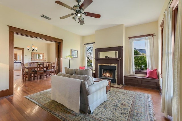 508 S Walnut St, Georgetown, TX 78626 - living room featuring a lit fireplace, a chandelier, a ceiling fan, and wood-type flooring