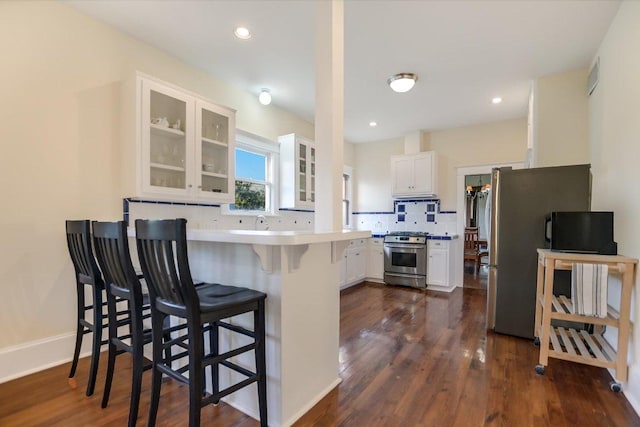 508 S Walnut St, Georgetown, TX 78626 - kitchen with appliances with stainless steel finishes, a peninsula, glass insert cabinets, white cabinets, and recessed lighting