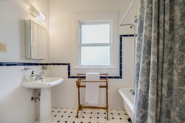 508 S Walnut St, Georgetown, TX 78626 - bathroom with tile walls, healthy amount of natural light, a wainscoted wall, and a sink