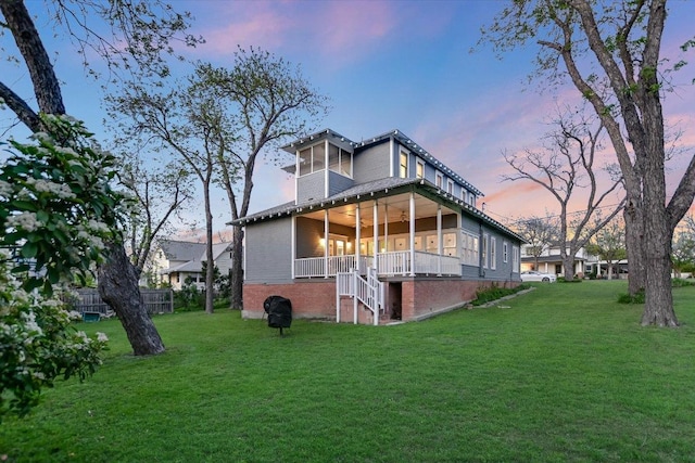 508 S Walnut St, Georgetown, TX 78626 - back of house at dusk featuring a yard, brick siding, and stairs