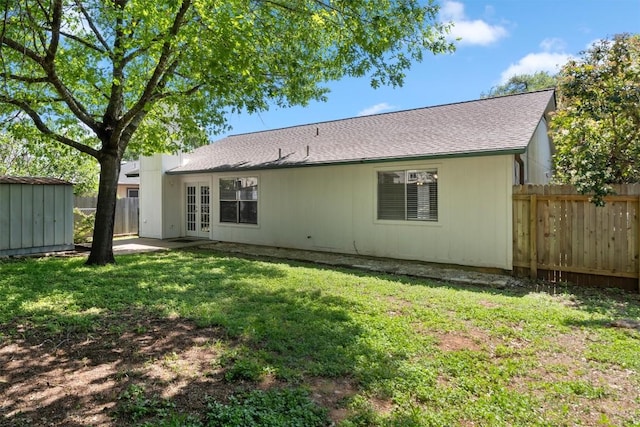 4902 Ganymede Dr, Austin, TX 78727 - back of house featuring french doors, a fenced backyard, a storage shed, and a shingled roof