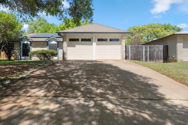 4902 Ganymede Dr, Austin, TX 78727 - view of front of property with stone siding, concrete driveway, roof mounted solar panels, and a garage