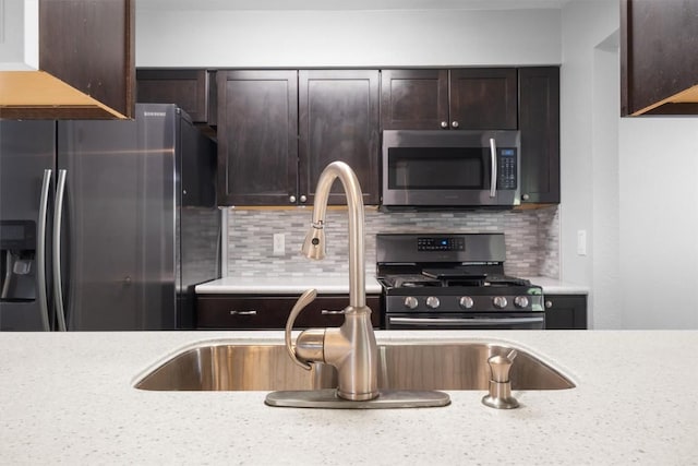 4902 Ganymede Dr, Austin, TX 78727 - kitchen featuring appliances with stainless steel finishes, dark brown cabinetry, and backsplash