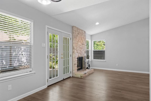 4902 Ganymede Dr, Austin, TX 78727 - unfurnished living room with wood finished floors, vaulted ceiling, baseboards, a stone fireplace, and recessed lighting