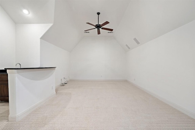 additional living space featuring carpet flooring, a ceiling fan, visible vents, vaulted ceiling, and baseboards