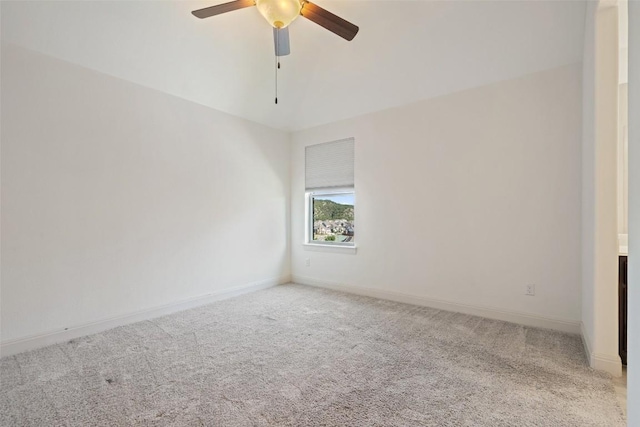 spare room with a ceiling fan, light colored carpet, and baseboards