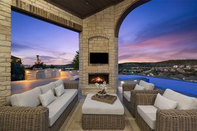 view of patio / terrace with an outdoor kitchen and an outdoor living space with a fireplace