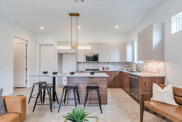 1713 E M Franklin Ave Unit 1, Austin, TX 78721 - kitchen featuring stainless steel appliances, modern cabinets, tasteful backsplash, a kitchen island, and a kitchen bar