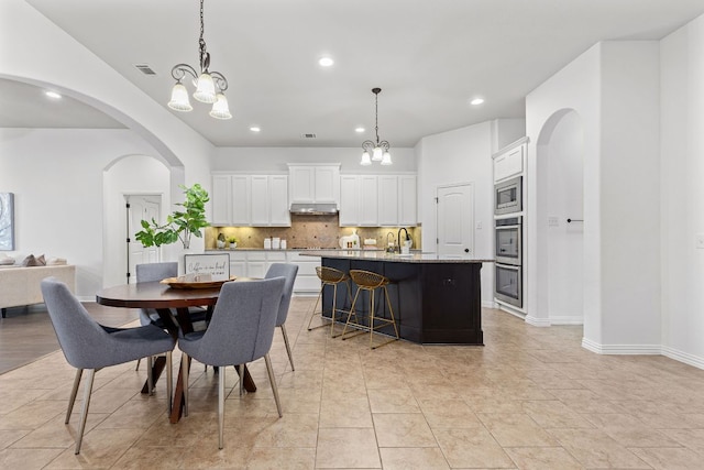 2632 Los Alamos Pass, Round Rock, TX 78665 - dining space featuring recessed lighting, arched walkways, a chandelier, baseboards, and light tile patterned floors