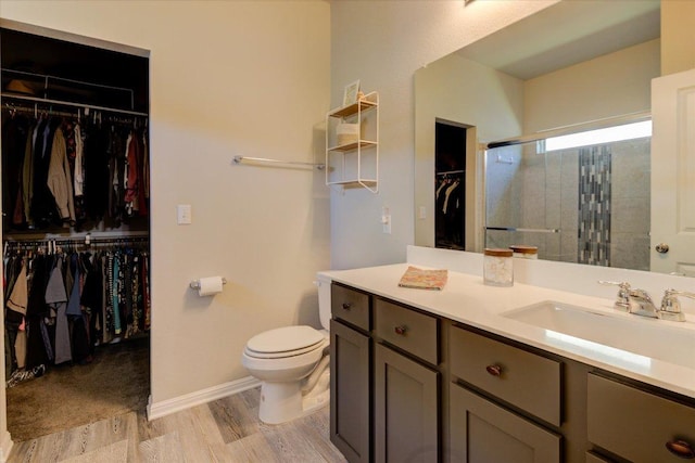 10312 Bankhead Dr, Austin, TX 78747 - bathroom featuring vanity, toilet, a shower stall, a spacious closet, and wood finished floors