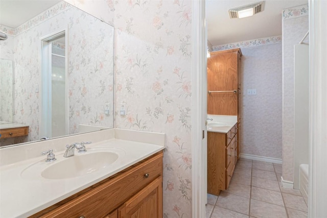 668 Sagewood Pkwy, Seguin, TX 78155 - bathroom featuring two vanities, tile patterned flooring, baseboards, and a bathtub