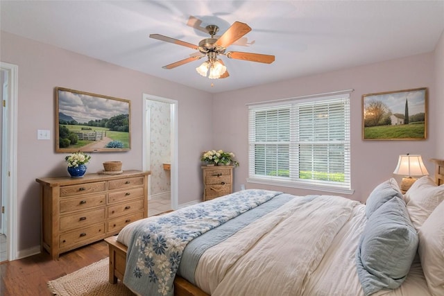 668 Sagewood Pkwy, Seguin, TX 78155 - bedroom featuring wood finished floors, baseboards, ceiling fan, and connected bathroom