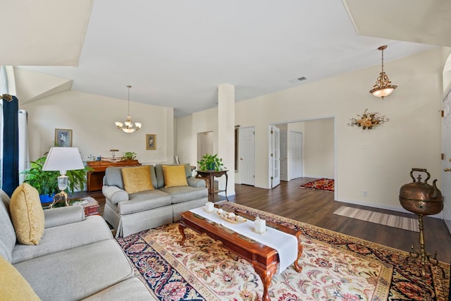living room with visible vents, baseboards, a notable chandelier, and wood finished floors