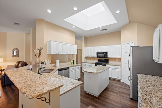 kitchen featuring visible vents, a sink, dark wood finished floors, black appliances, and a skylight