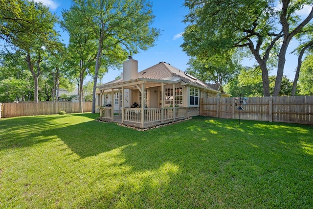 back of house with a pergola, a patio area, a fenced backyard, and a lawn