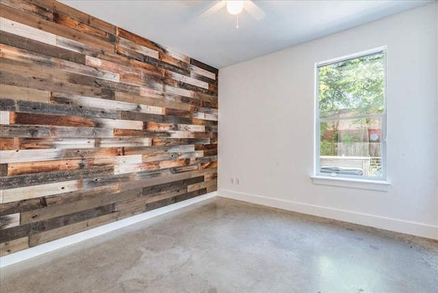 2608 E 6th St Unit 6, Austin, TX 78702 - unfurnished room featuring ceiling fan, baseboards, wooden walls, and concrete floors