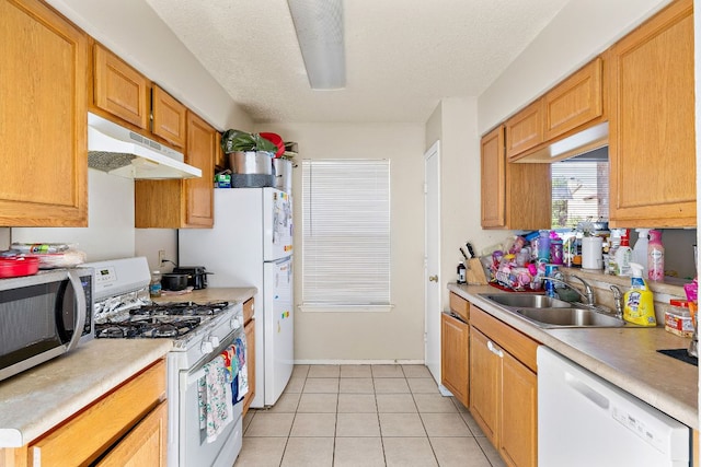 kitchen with light tile patterned floors, a sink, light countertops, white appliances, and under cabinet range hood