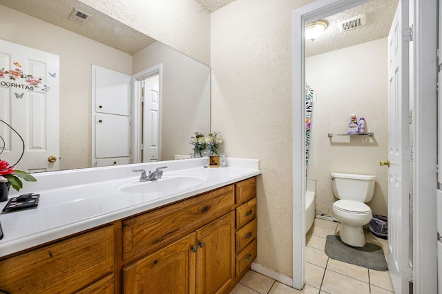full bathroom with tile patterned floors, vanity, a textured ceiling, and toilet