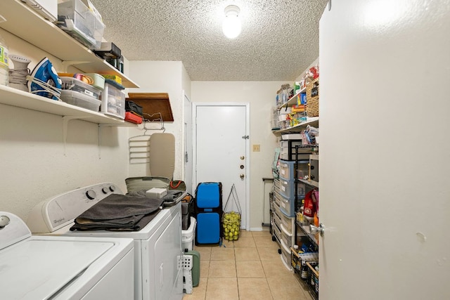 laundry room with laundry area, light tile patterned floors, a textured ceiling, and washer and clothes dryer