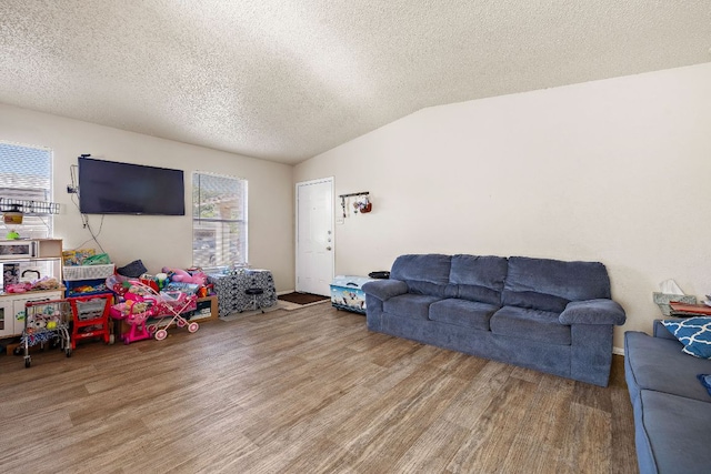 living area with lofted ceiling, a textured ceiling, and wood finished floors