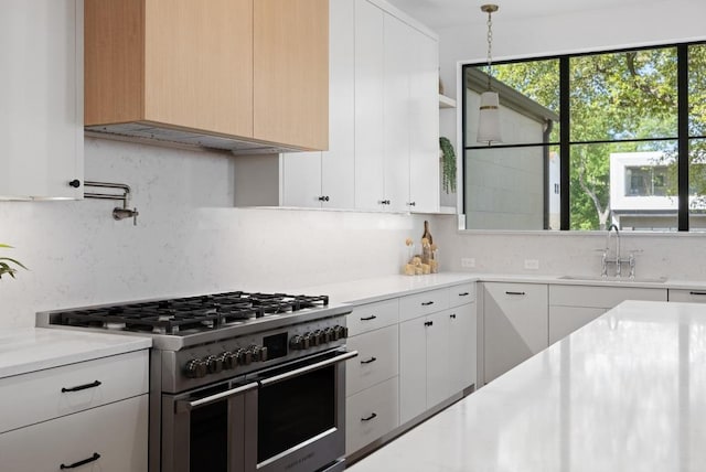3412 Rosefinch Trl, Austin, TX 78746 - kitchen with high end stainless steel range oven, light countertops, decorative backsplash, and white cabinetry