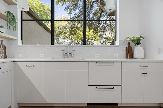 3412 Rosefinch Trl, Austin, TX 78746 - kitchen with open shelves, light countertops, white cabinetry, and decorative backsplash
