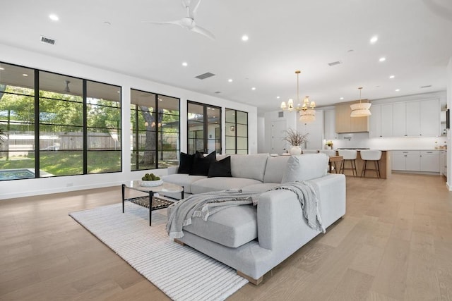 3412 Rosefinch Trl, Austin, TX 78746 - living area featuring plenty of natural light, light wood-type flooring, a ceiling fan, recessed lighting, and a chandelier