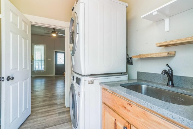 1132 W Clark St, Bartlett, TX 76511 - washroom featuring stacked washer / dryer, a ceiling fan, light wood-style flooring, and cabinet space