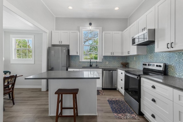 1132 W Clark St, Bartlett, TX 76511 - kitchen featuring appliances with stainless steel finishes, a sink, dark countertops, a kitchen breakfast bar, and recessed lighting