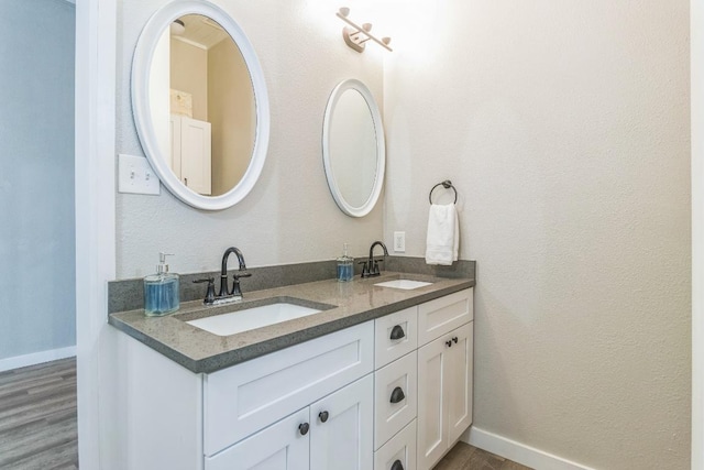 1132 W Clark St, Bartlett, TX 76511 - bathroom with wood finished floors, double vanity, and baseboards